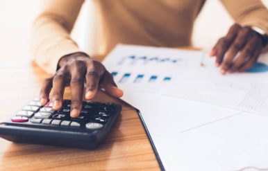 Budget Planning. Unrecognizable black businessman using calculator, tracking income and expenses. Panorama, copy space